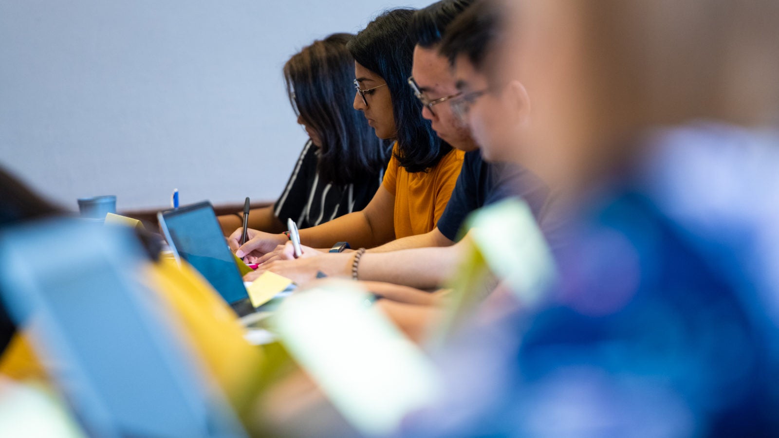 Students in a row take notes in a class at GA