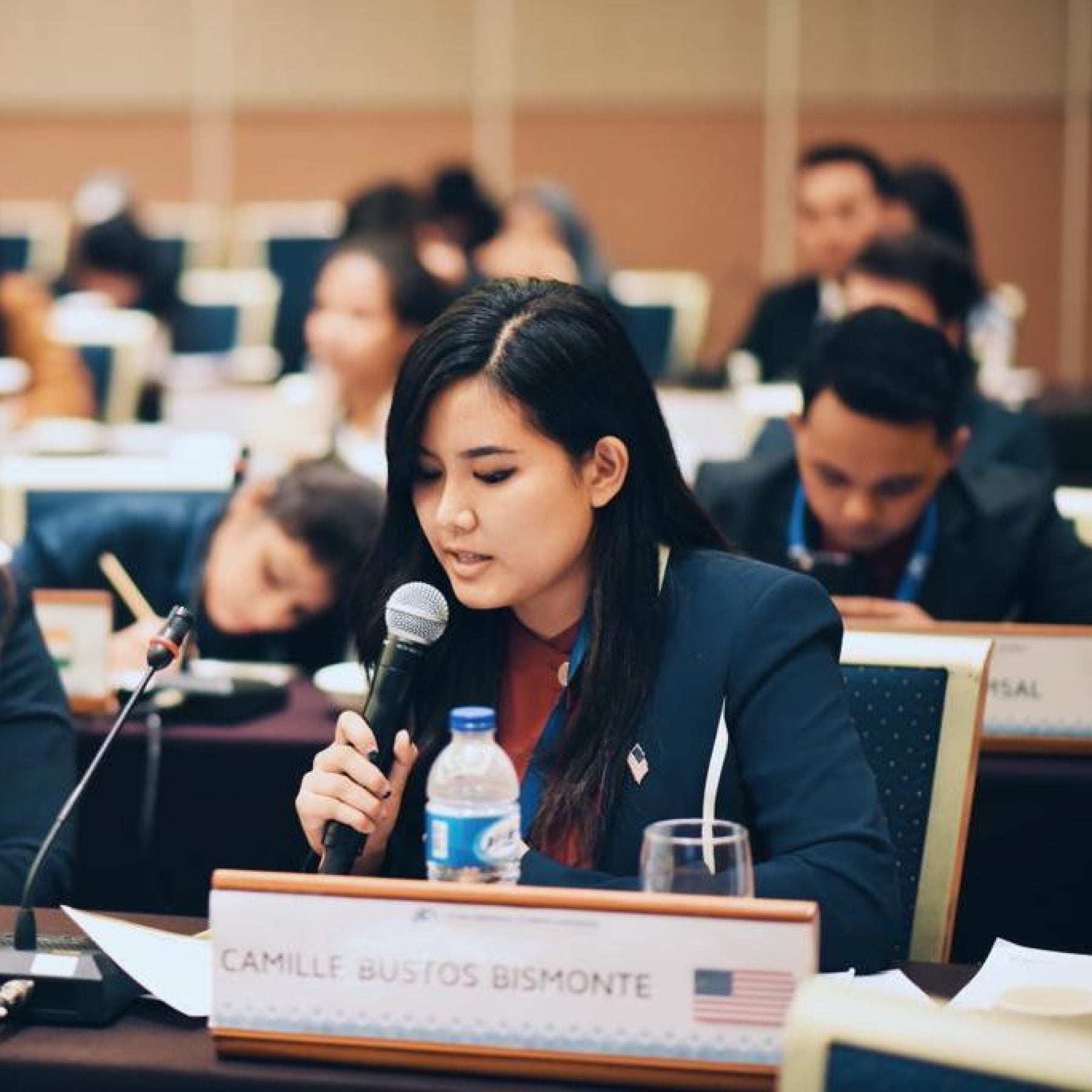 Camille Bustos Bismonte speaks into a microphone while testifying