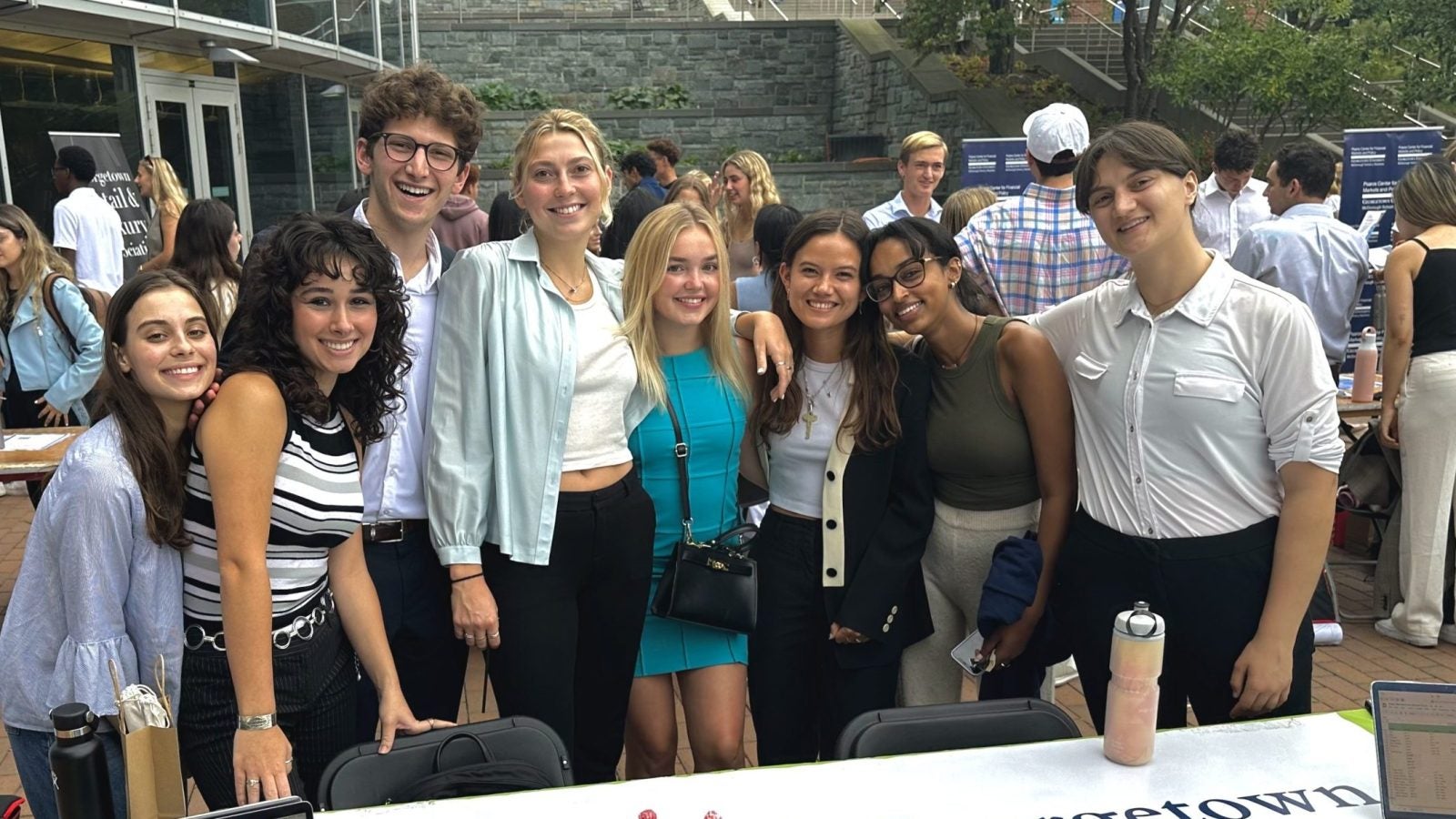 Students smile around a table adorned with a &quot;GA Eco-consultants&quot; sign