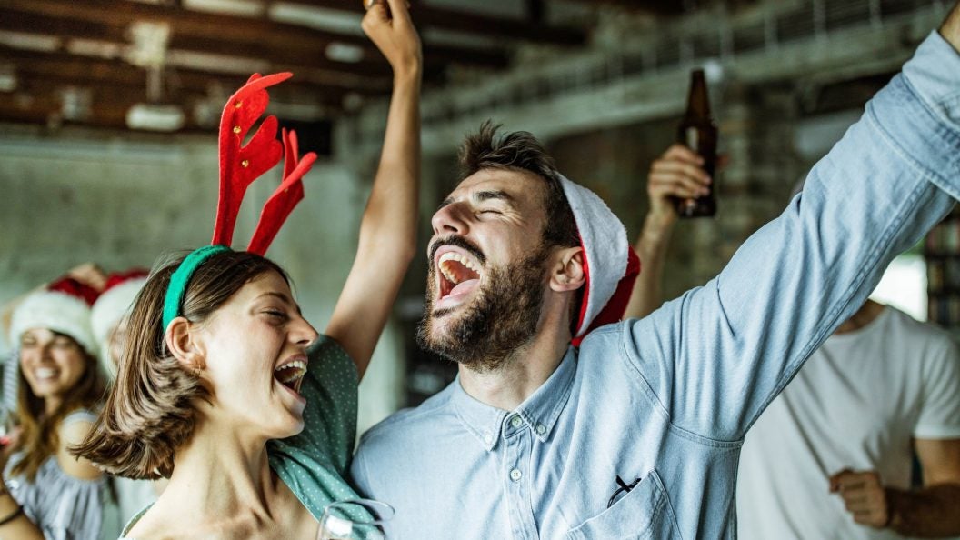 Happy couple having fun while singing on Christmas party.