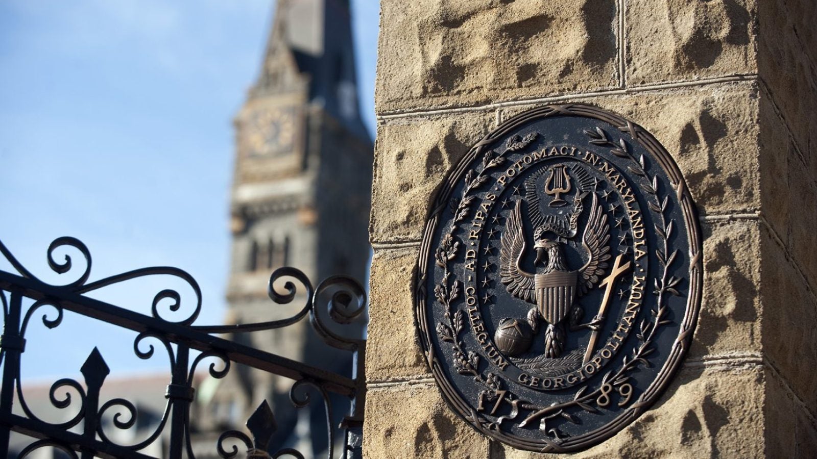 The seal of GA in stone at the gates of the Healy Building, shown in background